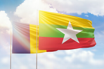 Sunny blue sky and flags of myanmar and romania
