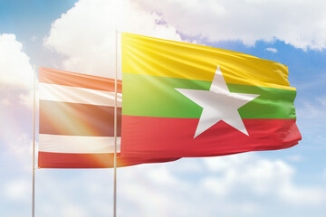 Sunny blue sky and flags of myanmar and thailand