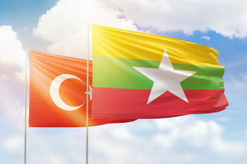 Sunny blue sky and flags of myanmar and turkey