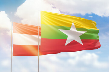 Sunny blue sky and flags of myanmar and austria