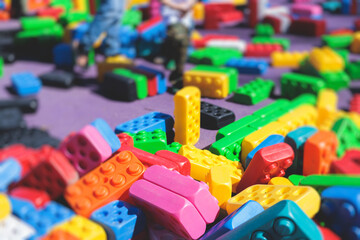 Children play colorful big toy blocks in kindergarten day care center playground, kids playing with various plastic mega construction blocks bricks