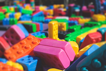 Children play colorful big toy blocks in kindergarten day care center playground, kids playing with various plastic mega construction blocks bricks