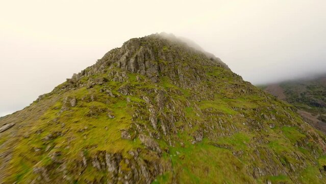 FPV Aerial view of snowdon summit in the distance covered in fog leading into diving the peak of snowdon down to the bottom
