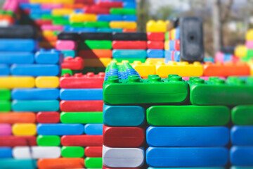 Children play colorful big toy blocks in kindergarten day care center playground, kids playing with various plastic mega construction blocks bricks