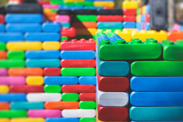 Children play colorful big toy blocks in kindergarten day care center playground, kids playing with various plastic mega construction blocks bricks