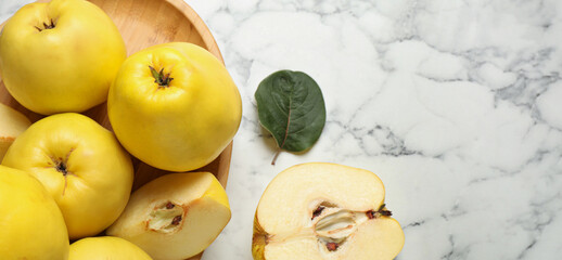 Naklejka na ściany i meble Fresh ripe organic quinces with leaves on white marble table, flat lay with space for text. Banner design