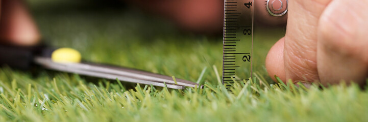 Man Using Measuring Scale While Cutting Grass