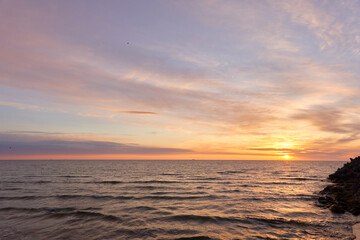 Baltic sea at sunset. Dramatic sky, blue and pink glowing clouds, soft golden sunlight, midnight...
