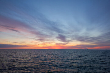 Baltic sea at sunset. Dramatic sky, blue and pink glowing clouds, soft golden sunlight, midnight...