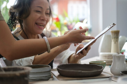Handmade craftsmanship retail store owners checking order on digital tablet. E-commerce, online selling, small business and technology concept.