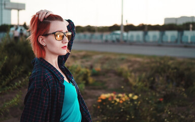 Woman with short ginger hair in urban environment. Sunset time.