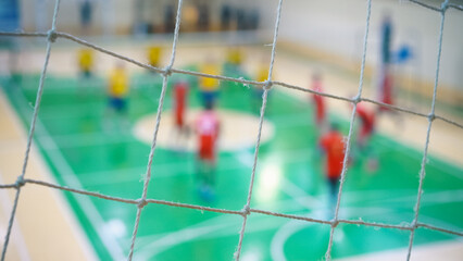 Sport mesh on blurred background of volleyball game, indoor. Teamwork concept, selective focus.