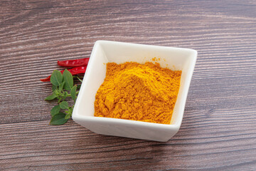 Yellow vibrant curcuma powder in the bowl