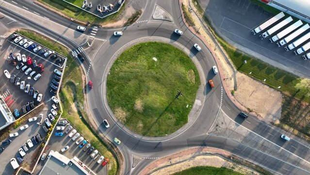 Aerial view of road roundabout intersection with fast moving heavy traffic. Urban circular transportation crossroads