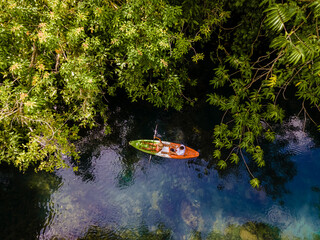couple in a kayak in the jungle of Krabi Thailand, men and woman in kayak at a tropical jungle in...