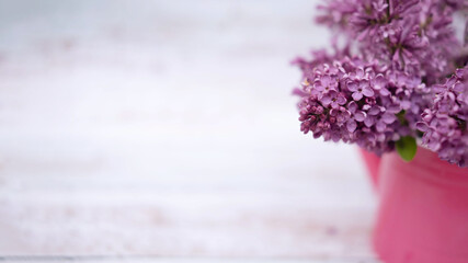 Lilac flowers in a watering can vase, close-up. Selective focus, copy space. The concept of the Valentine's Day holiday