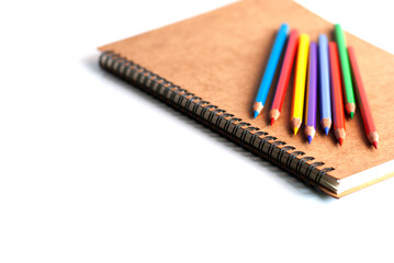 Fototapeta premium Color pencils and a book on white background.