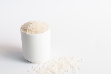 Jasmine rice in a white cup on white background.