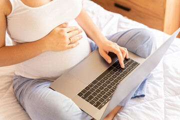 Pregnancy digital laptop. Pregnant woman holding digital computer. Mobile pregnancy online maternity notebook application. Concept of pregnancy, maternity, expectation for baby birth.