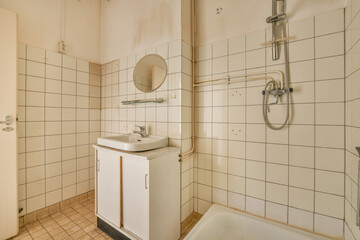 Interior of contemporary bathroom with shabby beige walls and partitions and white door at home
