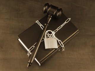 Censorship and information security concept. Wooden judge gavel on chained book.