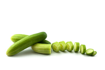 Three cucumbers and sliced on a white background.