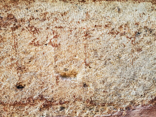 Light beige and brown porous limestone surface of an old stone wall. Beautiful grunge texture with roughness and scuffs in white, yellow and red shades