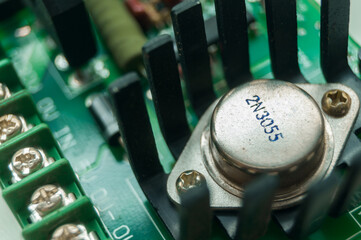 Power transistor with heatsink cooling on the electronic board. High-voltage electronics components. Selective focus