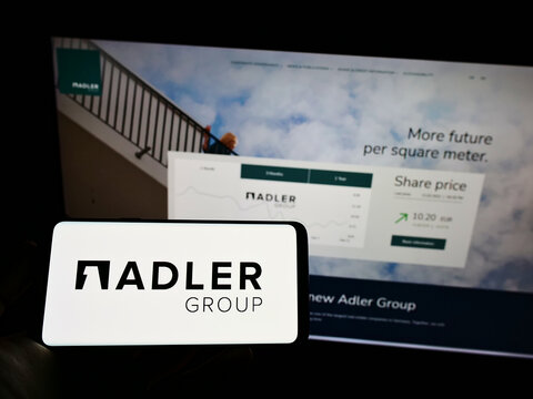 Stuttgart, Germany - 02-13-2022: Person holding cellphone with logo of real estate company Adler Group S.A. on screen in front of business webpage. Focus on phone display.