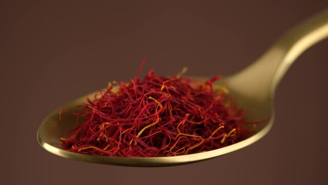 Saffron threads spice in golden spoon, close up. Most expensive spice