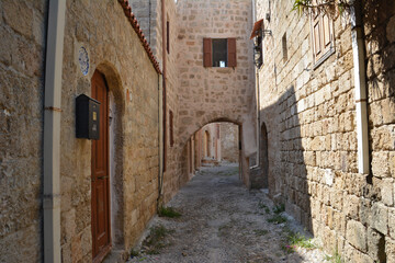 narrow medieval street with brick walls and arched doors and windows