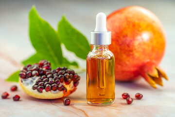 Pomegranate oil in a cosmetic bottle with a pipette. Natural cosmetics and face care.