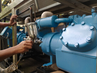 Repainting on the chiller compressor block using a spray gun.