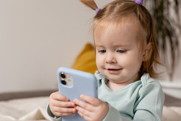 little girl is holding a smartphone in her hands. young blogger