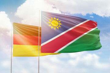 Sunny blue sky and flags of namibia and germany
