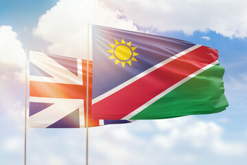 Sunny blue sky and flags of namibia and great britain
