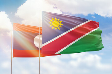 Sunny blue sky and flags of namibia and laos