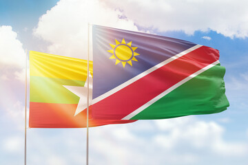 Sunny blue sky and flags of namibia and myanmar