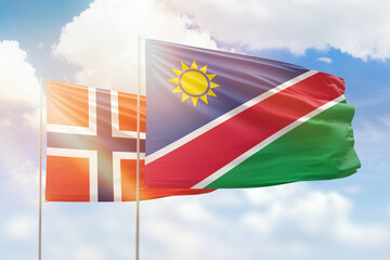 Sunny blue sky and flags of namibia and norway