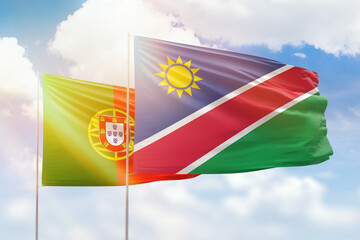 Sunny blue sky and flags of namibia and portugal