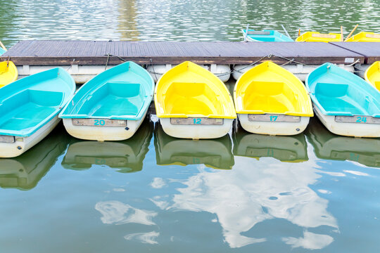 Many boats at the pier . Colorfull blue and yellow boats floating on water. Travel and recreation