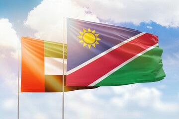 Sunny blue sky and flags of namibia and uae
