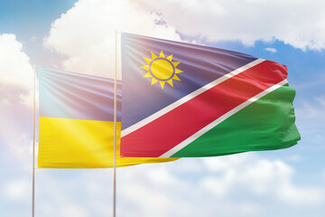 Sunny blue sky and flags of namibia and ukraine