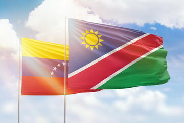 Sunny blue sky and flags of namibia and venezuela