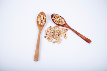 Puffed wheat covered with honey in wooden spoon isolated on white background.
