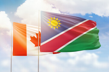 Sunny blue sky and flags of namibia and canada