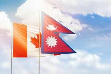 Sunny blue sky and flags of nepal and canada