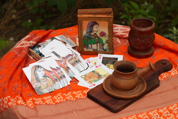 Kamasutra playing cards on table with orange tablecloth and coffee
