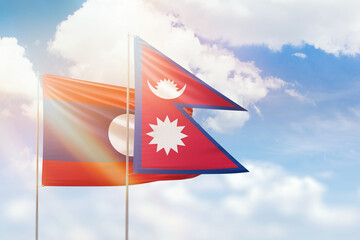 Sunny blue sky and flags of nepal and laos