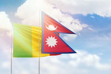Sunny blue sky and flags of nepal and mali